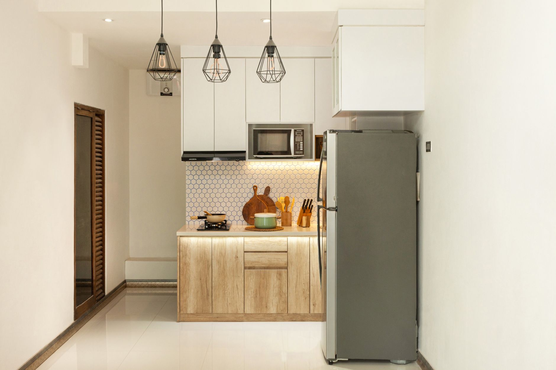 Lichte keuken met houten fronten, witte kasten en hanglampen